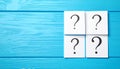 Paper cards with question mark on blue wooden background, top view. Space for text Royalty Free Stock Photo