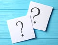 Paper cards with question mark on blue wooden background, top view. Space for text Royalty Free Stock Photo