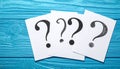 Paper cards with question mark on blue wooden background, top view. Space for text Royalty Free Stock Photo