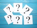 Paper cards with question mark on blue wooden background, top view. Space for text Royalty Free Stock Photo