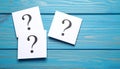 Paper cards with question mark on blue wooden background, top view. Space for text Royalty Free Stock Photo