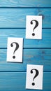 Paper cards with question mark on blue wooden background, top view. Space for text Royalty Free Stock Photo