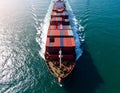 Aerial top view of cargo ship with contrail in the ocean ship carrying container Royalty Free Stock Photo