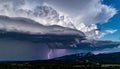 Dramatic thunderstorm over a mountainous landscape with a large, swirling cloud formation. Royalty Free Stock Photo