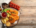 Tasty schnitzels served with potatoes, ketchup and vegetables on wooden table Royalty Free Stock Photo
