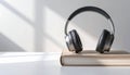 Cozy relaxation scene with headphones on book in soft natural light and minimalist interior Royalty Free Stock Photo