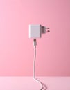 Pink background, USB power adapter and charging cable on flat panel. Royalty Free Stock Photo
