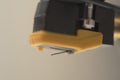 Macro close-up of yellow stylus phono cartridge mounted on headshell, precision analog audio component for turntable systems Royalty Free Stock Photo