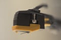 Macro close-up of yellow stylus phono cartridge mounted on headshell, precision analog audio component for turntable systems Royalty Free Stock Photo