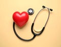 Stethoscope and heart model on color background, top view. Medical equipment Royalty Free Stock Photo