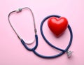 Stethoscope and heart model on color background, top view. Medical equipment Royalty Free Stock Photo