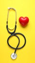 Stethoscope and heart model on color background, top view. Medical equipment Royalty Free Stock Photo
