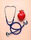 Stethoscope and heart model on color background, top view. Medical equipment Royalty Free Stock Photo