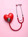 Stethoscope and heart model on color background, top view. Medical equipment Royalty Free Stock Photo