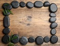 Frame made with spa stone on wooden table, top view. Space for text Royalty Free Stock Photo