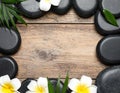 Frame made with spa stone on wooden table, top view. Space for text Royalty Free Stock Photo
