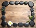 Frame made with spa stone on wooden table, top view. Space for text Royalty Free Stock Photo