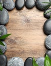 Frame made with spa stone on wooden table, top view. Space for text Royalty Free Stock Photo