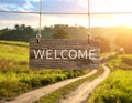 Welcome card. Wooden board with word hanging on rope in countryside Royalty Free Stock Photo