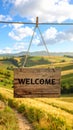 Welcome card. Wooden board with word hanging on rope in countryside Royalty Free Stock Photo