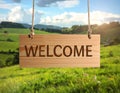 Welcome card. Wooden board with word hanging on rope in countryside Royalty Free Stock Photo