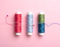 Meshes with colored sewing threads on a pink background, straight line Royalty Free Stock Photo
