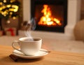 Cup of hot drink near fireplace at home. Space for text Royalty Free Stock Photo