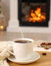 Cup of hot drink near fireplace at home. Space for text Royalty Free Stock Photo