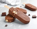 Delicious glazed ice cream bars and chocolate on light grey marble table Royalty Free Stock Photo