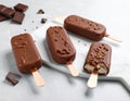 Delicious glazed ice cream bars and chocolate on light grey marble table Royalty Free Stock Photo