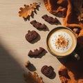 A cozy autumn scene featuring a latte with frothy milk and cinnamon on a light wooden table. Royalty Free Stock Photo