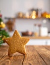 Star-Shaped Gingerbread Cookie on Rustic Wooden Surface with Holiday Kitchen Background Royalty Free Stock Photo