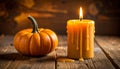 Rustic Halloween still life with small orange pumpkin and dripping yellow pillar candle on weathered wooden planks Royalty Free Stock Photo
