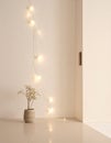 Single String of White Lights on Beige Wall Royalty Free Stock Photo