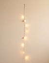 Single String of White Lights on Beige Wall Royalty Free Stock Photo