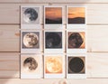 Collection of moon phase photos on rustic wooden table under warm light Royalty Free Stock Photo