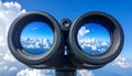 Binoculars with blue sky and clouds reflected in the lenses - future vision metaphor Royalty Free Stock Photo