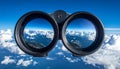 Binoculars with blue sky and clouds reflected in the lenses - future vision metaphor Royalty Free Stock Photo