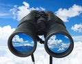 Binoculars with blue sky and clouds reflected in the lenses - future vision metaphor Royalty Free Stock Photo