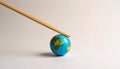 Colorful small globe held with wooden chopsticks on light gray background Royalty Free Stock Photo