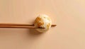 Minimalist conceptual image of white steamed chinese dumpling shaped like globe with golden landmasses held by wooden chopsticks Royalty Free Stock Photo