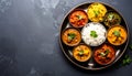 top down view of indian thali platter with small metal bowls of colorful curries red yellow green served with basmati rice Royalty Free Stock Photo