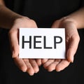 Woman holding piece of paper with word Help on black background, closeup. Domestic Royalty Free Stock Photo