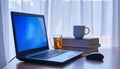 Laptop on Desk with Tea and Books Workspace Home Office Technology Concept Royalty Free Stock Photo