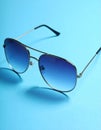 Stylish sunglasses on blue background. Fashionable accessory Royalty Free Stock Photo