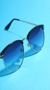 Stylish sunglasses on blue background. Fashionable accessory Royalty Free Stock Photo