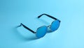 Stylish sunglasses on blue background. Fashionable accessory Royalty Free Stock Photo