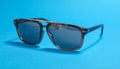 Stylish sunglasses on blue background. Fashionable accessory Royalty Free Stock Photo