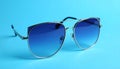 Stylish sunglasses on blue background. Fashionable accessory Royalty Free Stock Photo
