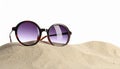 Stylish sunglasses on sand against white background. Space for text Royalty Free Stock Photo